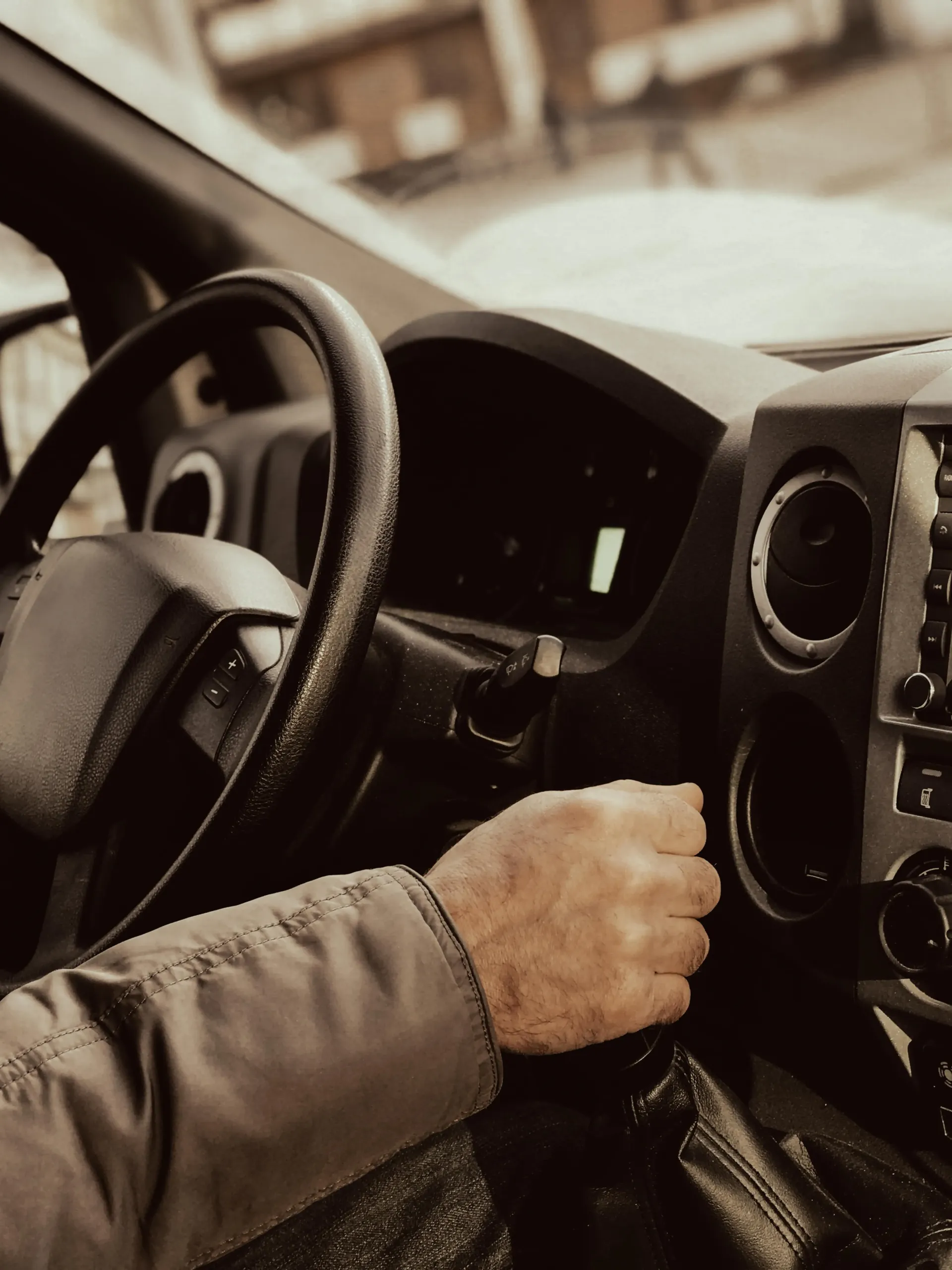 sécurité véhicule : Intérieur d'une voiture avec un homme tenant le pommeau de vitesse
