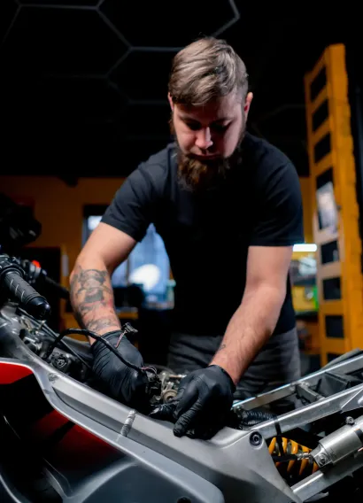 sécurité véhicule : Homme travaillant sur un moteur d'une moto