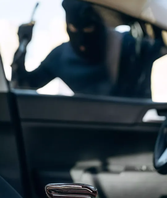 sécurité véhicule : Un voleur derrière la vitre d'une voiture